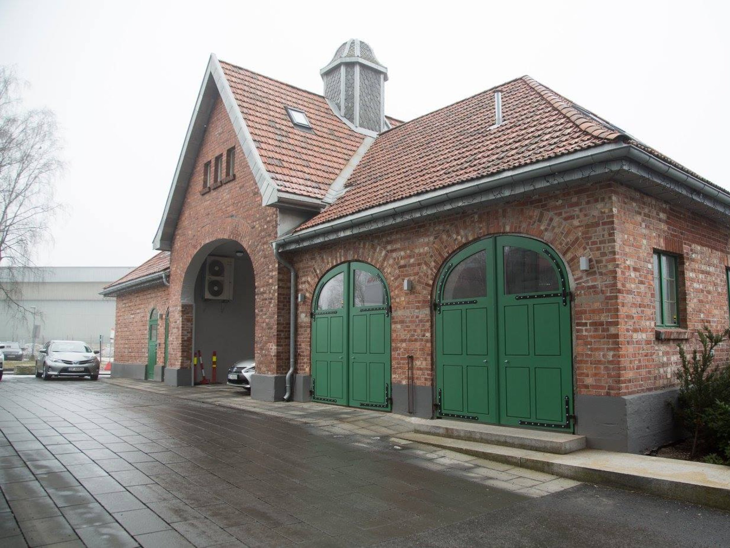 Murbygning med store grønne dører